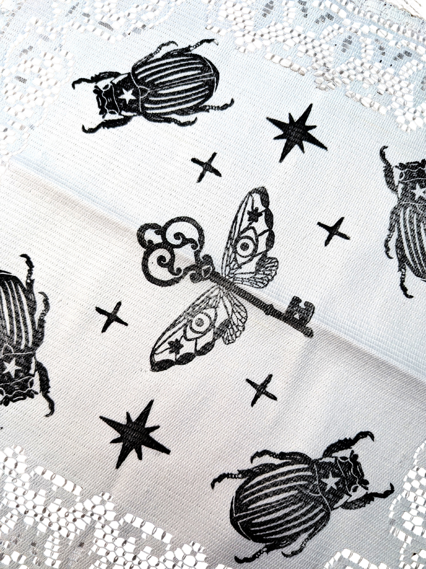 White doily with black Key & Bugs