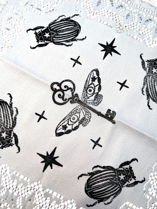 White doily with black Key & Bugs